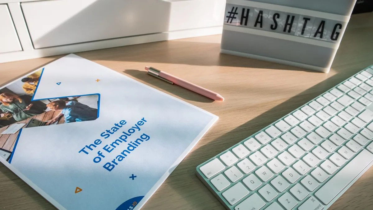 Printed brand guidelines, approved content examples, audience notes, and a laptop grouped in one workspace (Photo by Walls.io, Pexels)