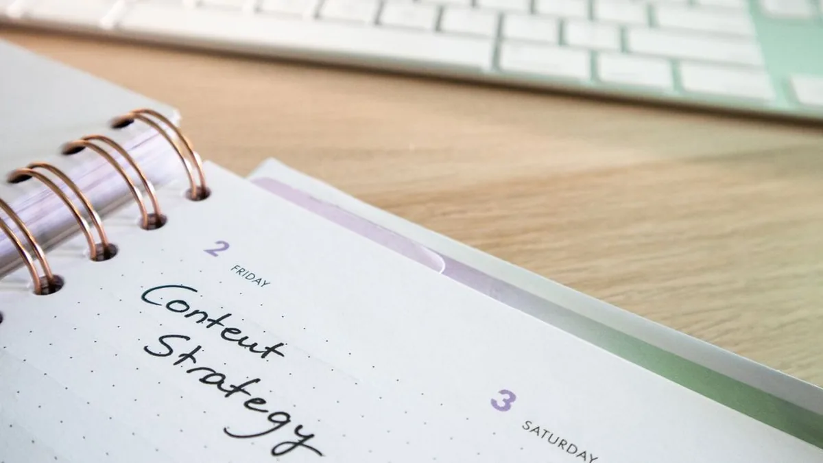 A creator preparing a batch of social posts beside a visible content calendar (Photo by Walls.io, Pexels)