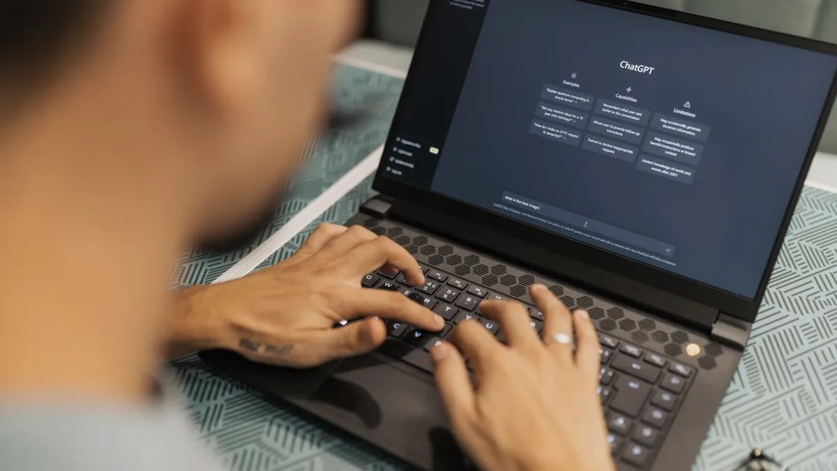 A developer tests a business chatbot on a smartphone beside an open laptop (Photo by Matheus Bertelli, Pexels)