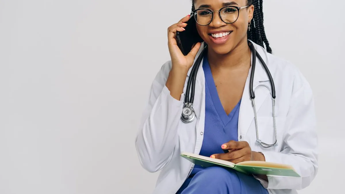 A receptionist or customer arranging an appointment by phone while viewing a calendar (Photo by Tessy Agbonome, Pexels)