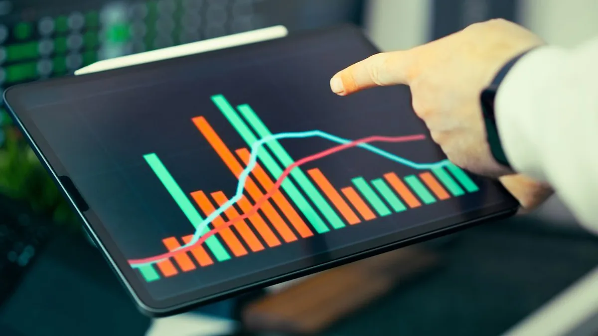 A project lead reviewing charts and workload indicators on a large computer monitor (Photo by Jakub Zerdzicki, Pexels)