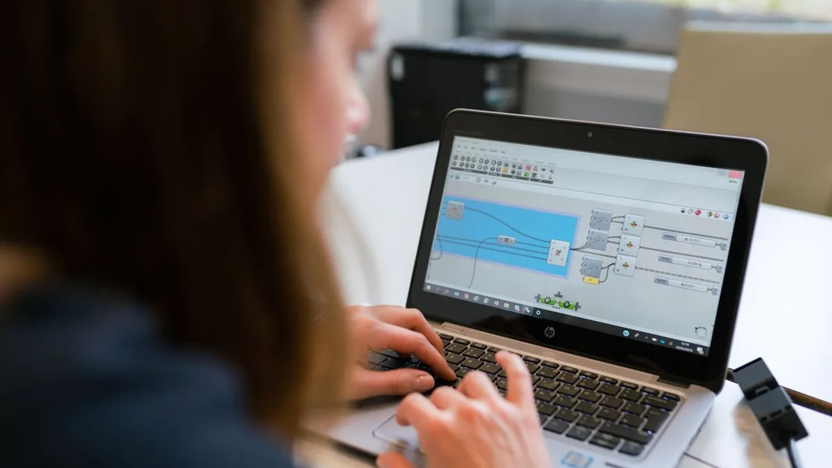 A laptop displaying a visual automation workflow beside a completed client onboarding form (Photo by ThisIsEngineering, Pexels)