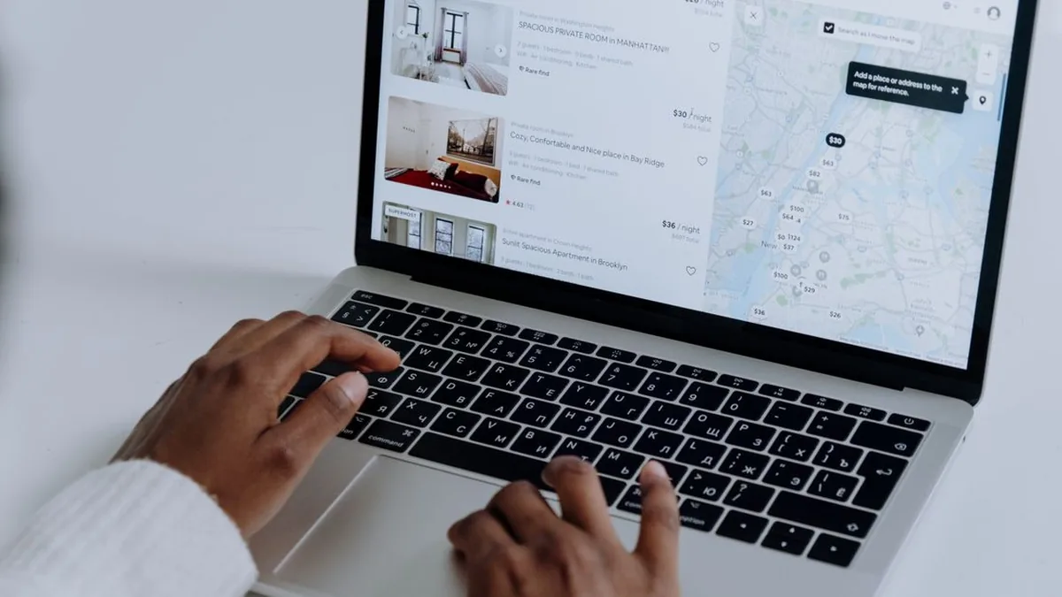A person submitting a property inquiry form on a laptop with a phone nearby (Photo by cottonbro studio, Pexels)