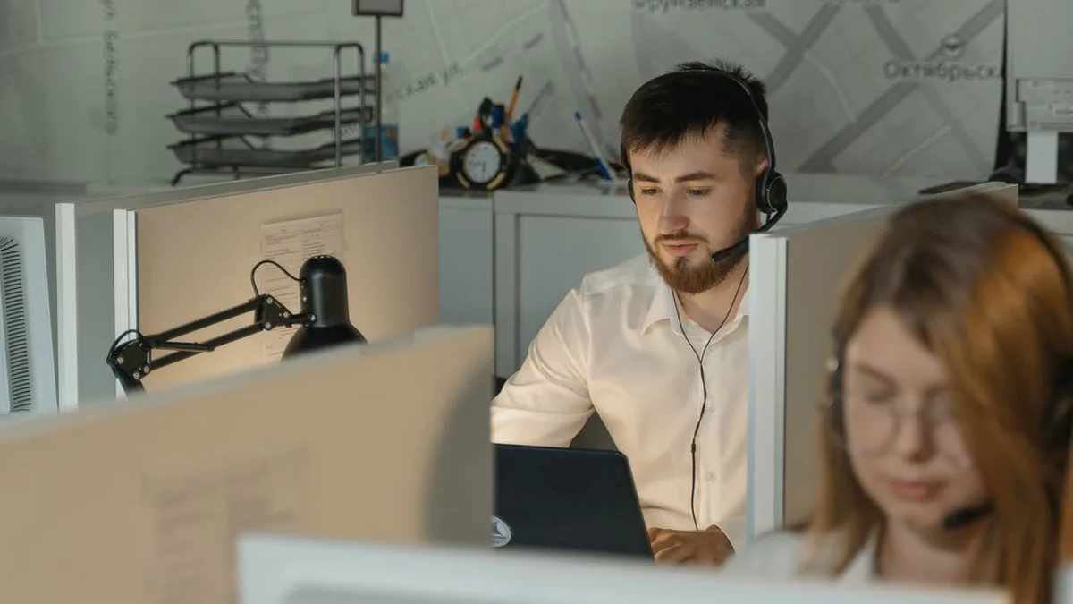 A support agent reviews customer conversations at a clean computer workstation (Photo by Tima Miroshnichenko, Pexels)