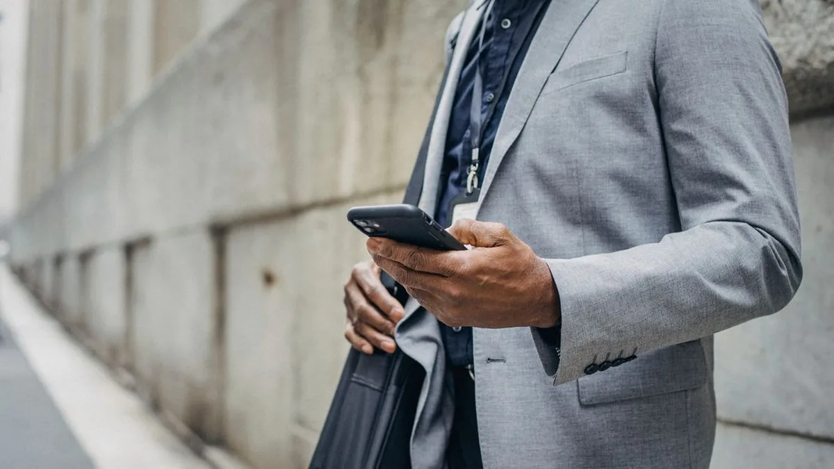 A business owner reviewing and replying to customer messages on a smartphone at a desk (Photo by Ono  Kosuki, Pexels)