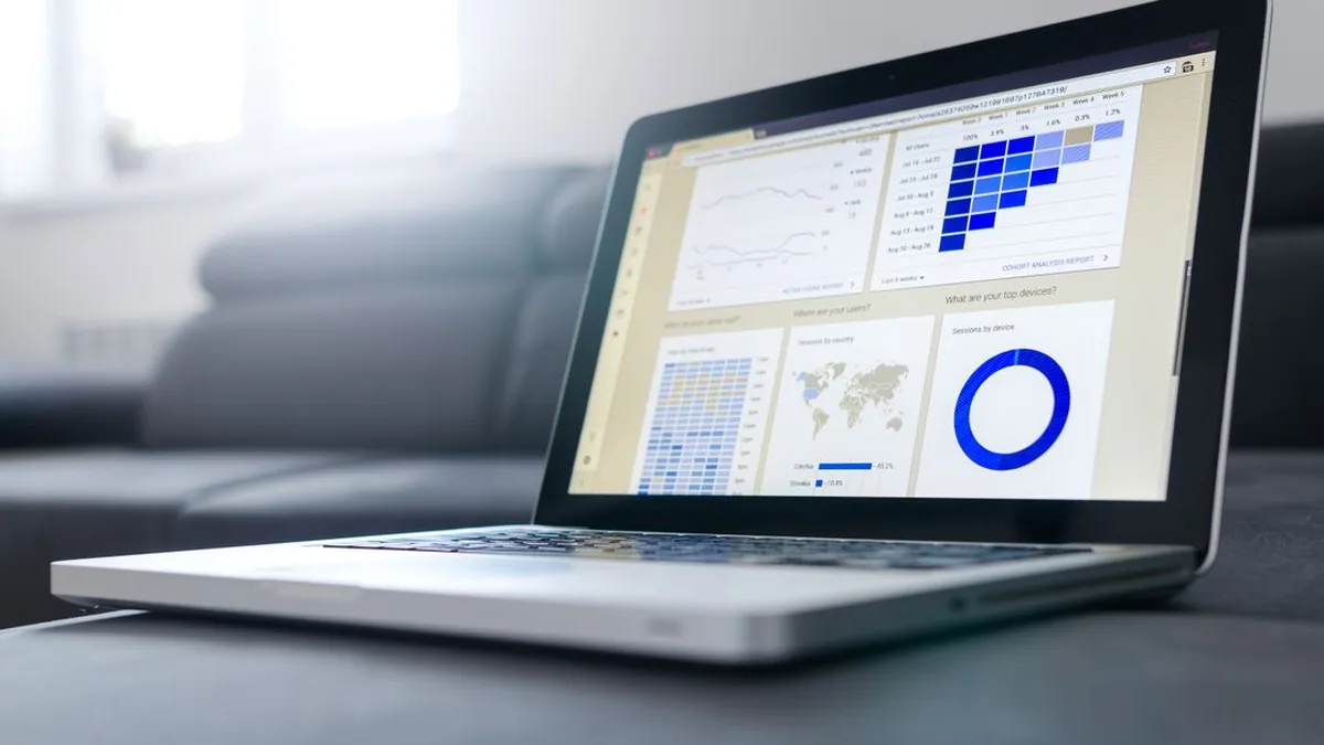 A laptop displaying a customer workflow dashboard beside campaign planning notes (Photo by Lukas Blazek, Pexels)