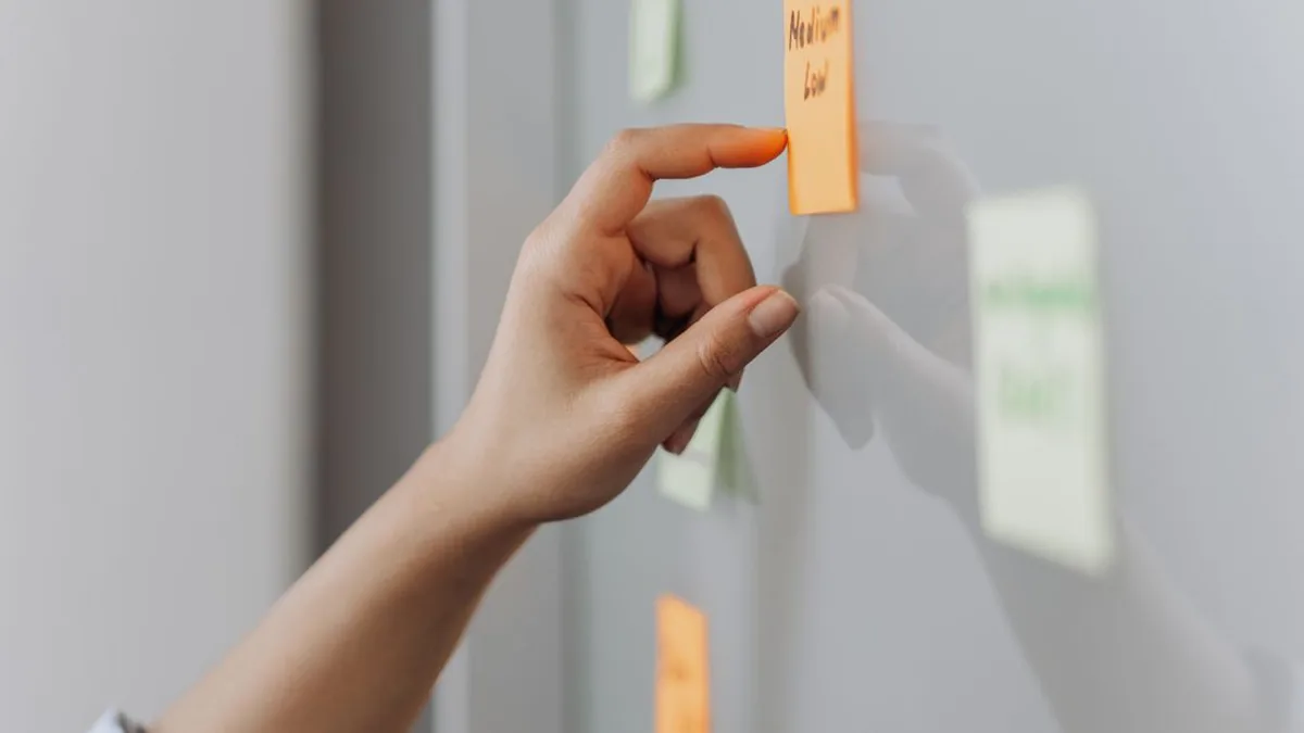 A designer creating a social graphic and adding it to a publishing calendar (Photo by Mikhail Nilov, Pexels)