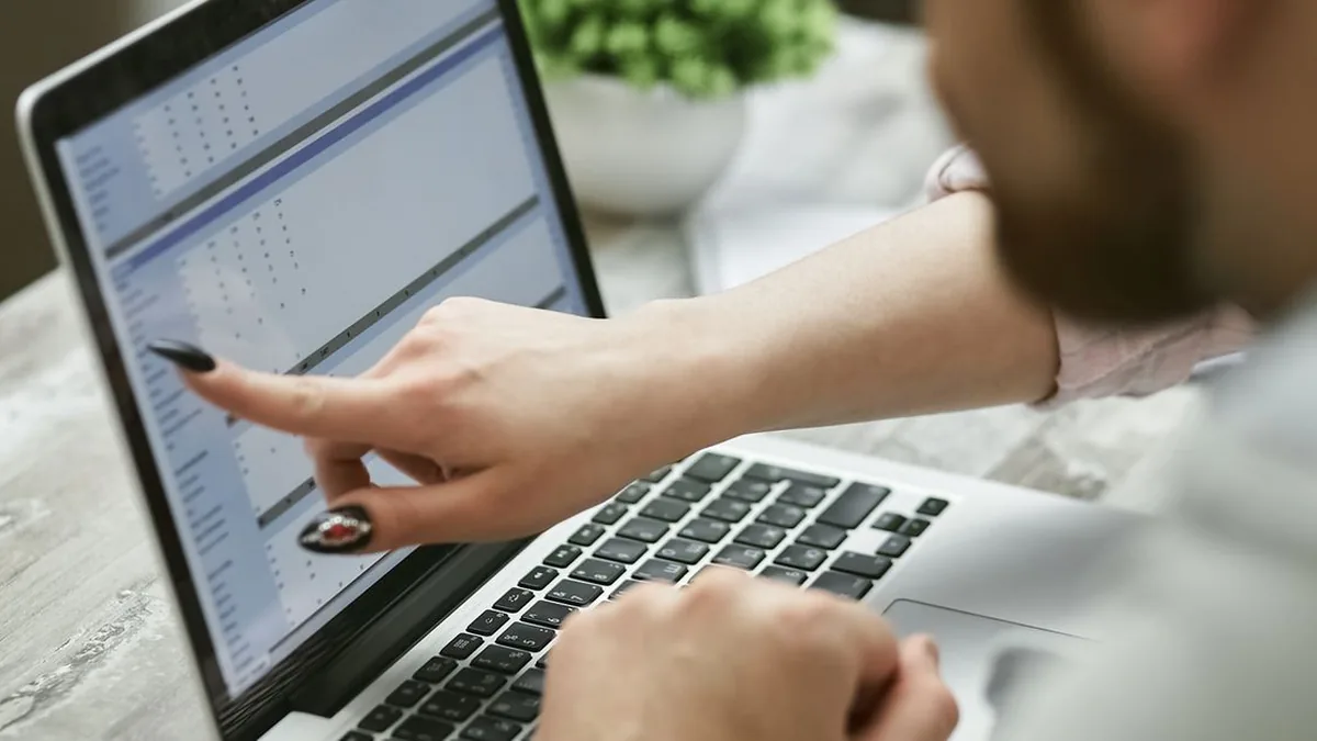 Two business applications are open on adjacent screens while contact data is reviewed for consistency (Photo by Mikhail Nilov, Pexels)