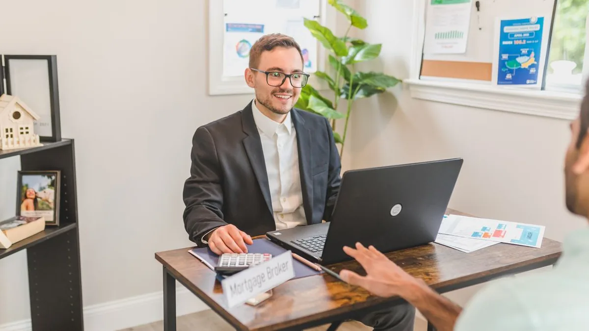 A mortgage advisor reviewing a borrower record on a laptop in a bright office (Photo by RDNE Stock project, Pexels)