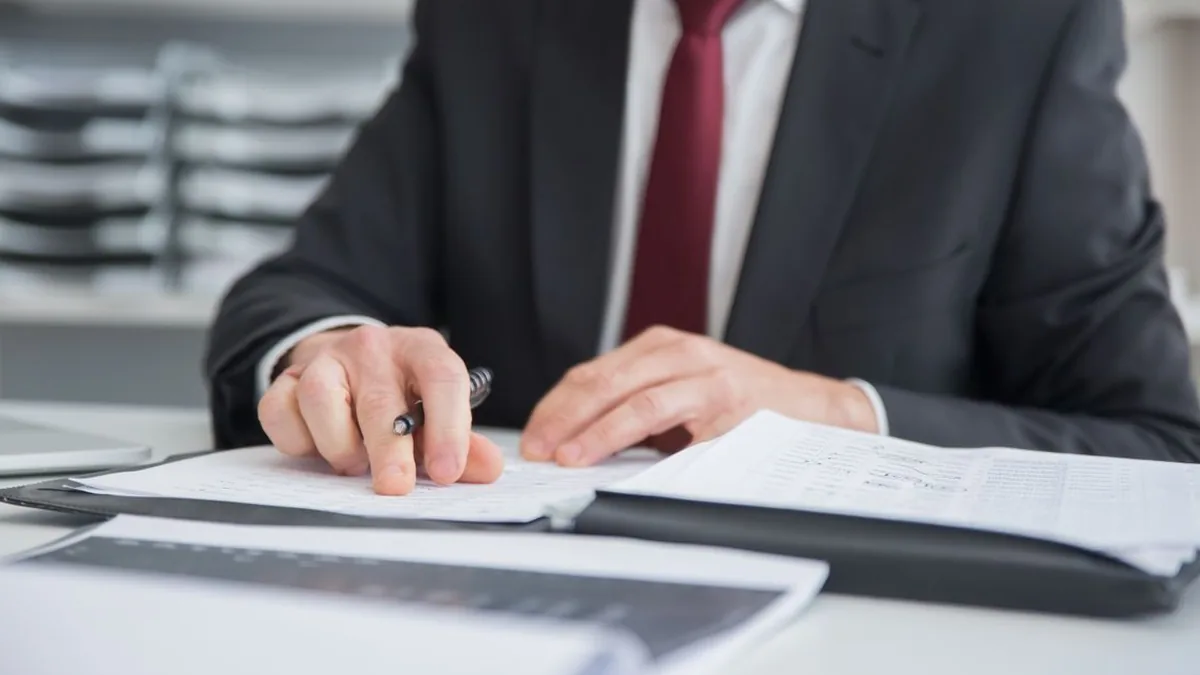 An analyst compares several reports while using an AI assistant for knowledge work (Photo by Kampus Production, Pexels)